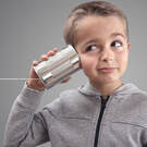 little boy with tin can and string held up to his ear like telephone