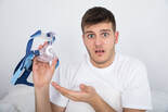young man holding cpap with perplexed expression